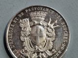 un gros plan d'une pièce d'argent sur laquelle figure un blason