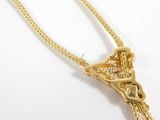 a gold necklace with a knot on it on a white surface