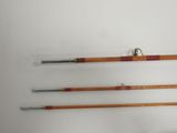 three fishing rods are lined up against a white wall