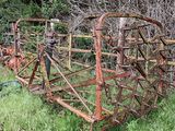 un engin agricole rouillé abandonné dans l'herbe