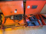 deux boîtes orange contenant des outils, posées par terre