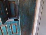 une armoire bleue dont la porte est ouverte, dans un coin de la pièce
