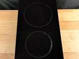 a black stove top with two burners on a wooden table