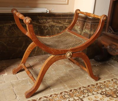 a wooden bench with a woven seat in a room