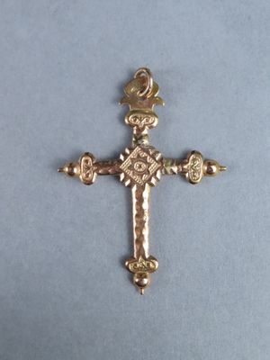 a close up of a cross on a table with a blue background