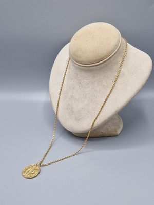 un collier en or sur une tête de mannequin, muni d'une chaîne en or
