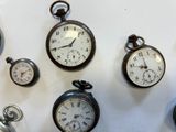 many different types of pocket watches displayed on the wall
