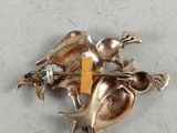 silver plated duck brooch with a yellow tag on it