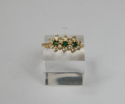 a close up of a gold ring with green stones on it