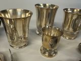 four silver vases sitting on a table next to each other