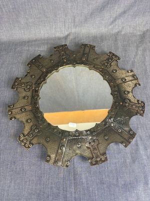 an old mirror with a metal frame and some metal decorations