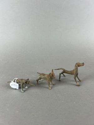 trois figurines représentant des chiens et un chat posées sur une table