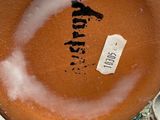 a brown bowl with a tag on it sitting on a table