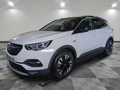 un SUV Opel blanc garé sur un sol à damier