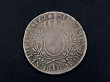 a close up of a silver coin on a black surface