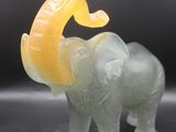 yellow and green jade elephant figurine on a black surface