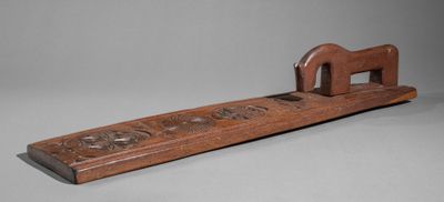 an image of a wooden object with carvings on it on a gray surface