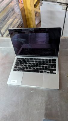 a laptop computer sitting on a table in a warehouse