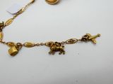 a close up of a gold necklace with charms on it