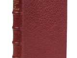a close up of a book with a red cover on a white surface