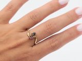 la main d'une femme portant une bague en or sertie d'un diamant noir