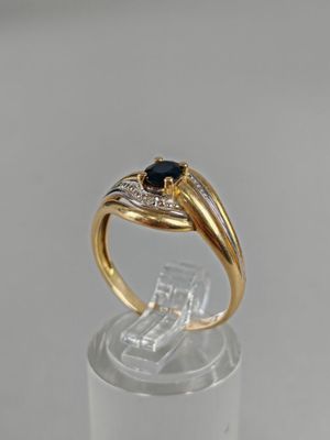 BAGUE en or jaune et gris (750/°°°) sertie d'un saphir.