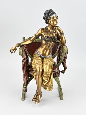 bronze statue of a woman sitting on a chair with her hand on her chin