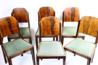 six chaises en bois aux assises rembourrées vertes sont disposées en cercle