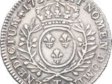 a silver coin with a crown and laurel on it