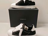 une paire de baskets noires et blanches dans une boîte noire