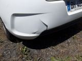 a white car that has a dent in the front of it