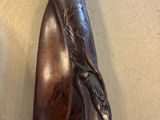 statue d'une femme tenant un poisson sur une planche en bois