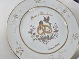a white plate with a gold design on it next to other plates
