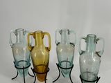 cinq vases en verre posés sur un support en métal