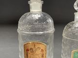 two clear glass bottles with a label on the top of them