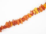 un gros plan sur un collier composé de perles orange et jaunes