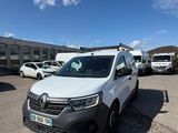 une camionnette blanche garée sur un parking à côté d'un bâtiment