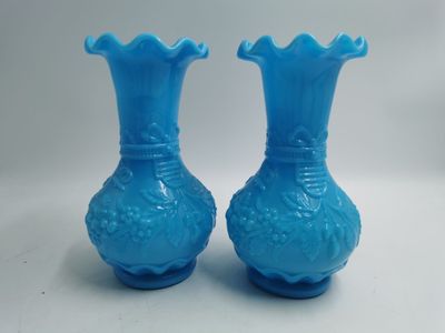 une paire de vases en verre bleu posés sur une table blanche