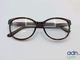 Ces lunettes sont en plastique et ont une monture marron.