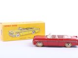 une petite voiture rouge à côté d'une boîte jaune sur une surface blanche