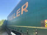 a large green truck that is parked on the side of the road