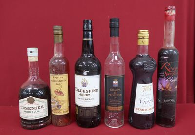 bottles of alcohol lined up on a table with a red background