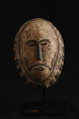un gros plan d'un masque en bois sur fond noir