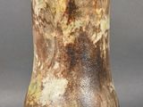 a vase that is sitting on a table in front of a gray background