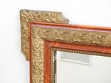 a mirror that is on the wall with a gold frame