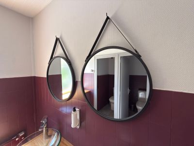 two mirrors on the wall above a sink in a bathroom