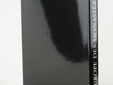 a black book sitting on top of a white table next to a white wall