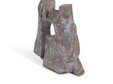 a stone sculpture of a man and a woman sitting on a rock