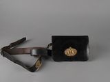 un sac à main noir avec une boucle dorée et une bandoulière marron