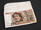 a stack of paper money sitting on a black surface
